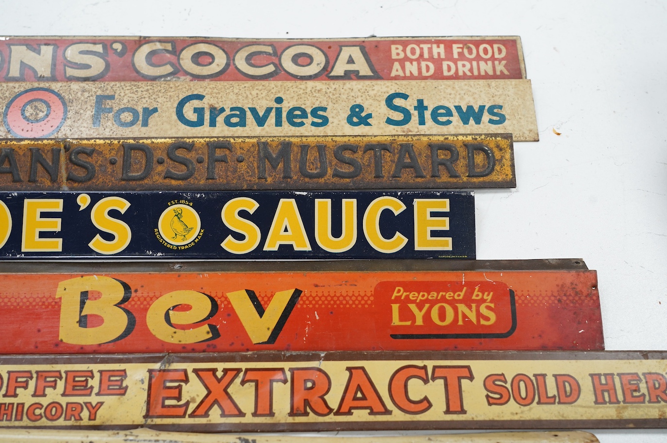Eleven early / mid 20th century tinplate advertising shelf strips, largest 60cm. Condition - fair